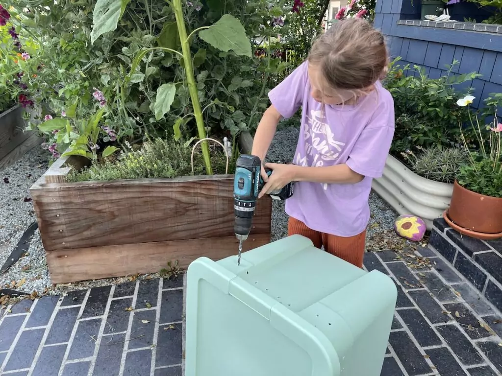 The first step to making a vermicompost bin is drilling the holes.