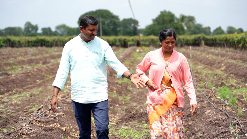 Two people walking hand in hand across their farm.